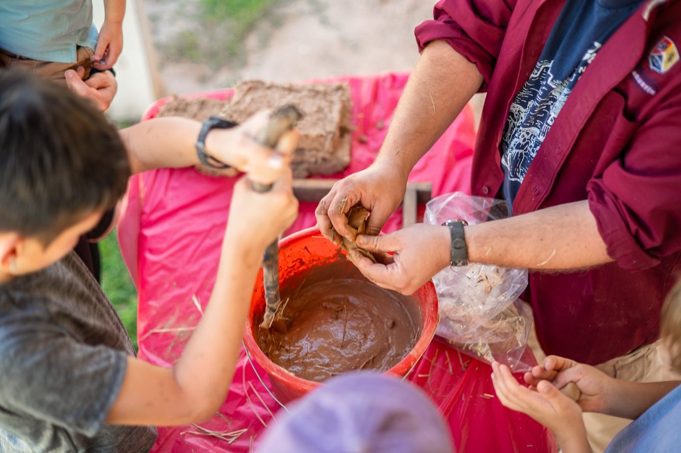 Campers working mud for adobe bricks