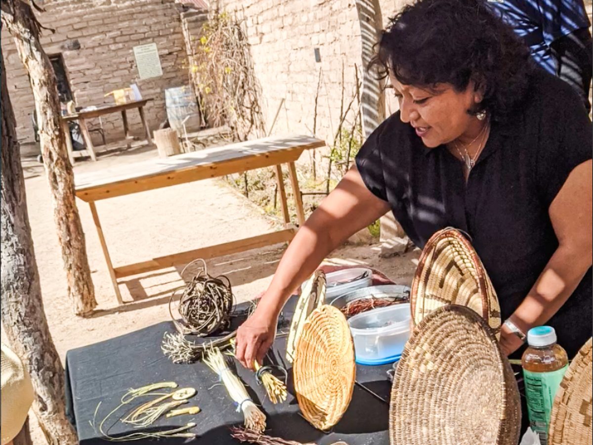 A traditional basket weaver sharing her craft with campers
