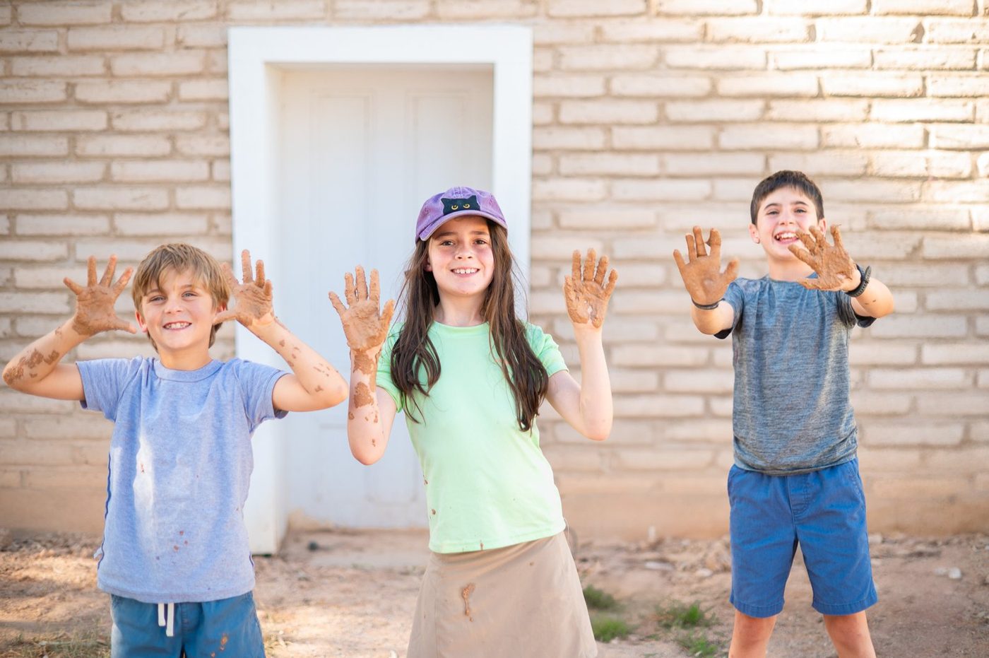 Campers showing off their muddy hands